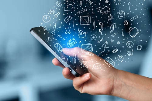 Hand holding smartphone with hand drawn media icons and symbols concept Hand holding smartphone with hand drawn media icons and symbols concept